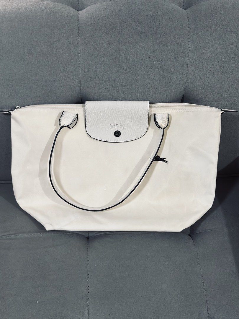 Longchamp Le Pliage White Tote Bag (Category: Luxury Bags & Wallets) located in Tarlac. Submitted by via_banana (Listing ID 1468409670, Image 1). Description: - Color: Classic White - Material: Durable nylon with leather handles and black edge detailing - Closure: Secure top zipper with snap flap - Details: Iconic embroidered horse logo on the front - Features: Spacious interior, lightweight, and foldable design - Best For: Daily essentials, scho