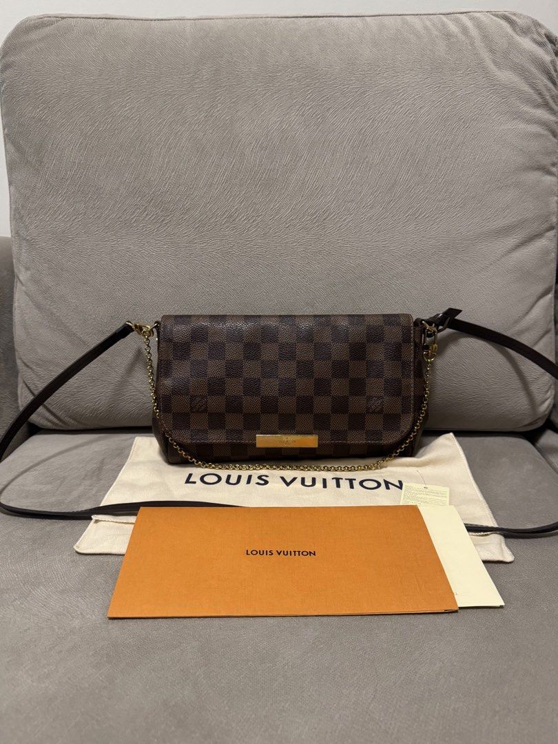 Louis Vuitton favorite (Category: Luxury Bags & Wallets) located in Taguig. Submitted by byebyebabies (Listing ID 1468302735, Image 2). Description: - Brand: Louis Vuitton - Material: Iconic Damier Ebene canvas with brown leather shoulder strap - Hardware: Elegant gold-tone chain strap and front plaque - Interior: Vibrant red lining inside the flap - Inclusions: Original cream dust bag and orange paper envelope - Condition: Excellent, well-mainta