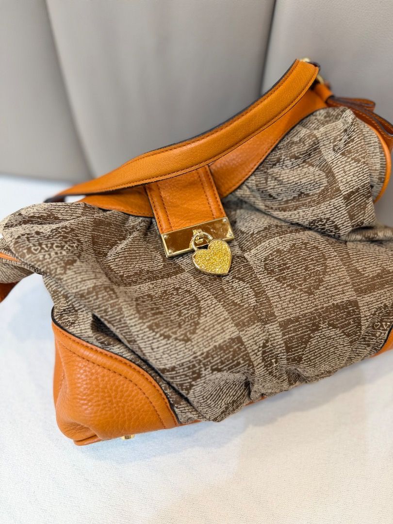 LOVCAT Paris Brown Orange Heart Pattern Shoulder Bag (Category: Shoulder Bags) located in Rizal. Submitted by je_resada (Listing ID 1468433001, Image 2). Description: - Authentic LOVCAT Paris shoulder bag - Brown fabric featuring a chic heart geometric pattern - Vibrant orange leather trim and adjustable strap - Elegant gold-tone hardware with clasp closure and hanging heart padlock charm - Structured base equipped with metal protective feet - Ro