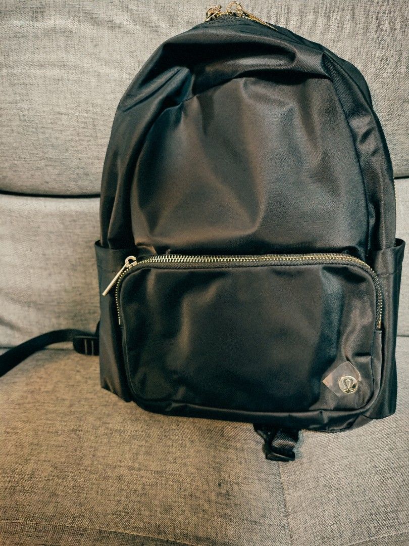 Lululemon Black Backpack with Gold Zippers (Category: Backpacks) located in Makati City. Submitted by momsieapril (Listing ID 1468354476, Image 2). Description: - Brand: Lululemon - Color: Black with chic gold-toned hardware - Material: Durable, high-quality nylon - Storage: Spacious main compartment, front zippered pocket, and side slip pockets - Details: Iconic logo badge on the front, brand-engraved zipper pulls, and adjustable shoulder straps