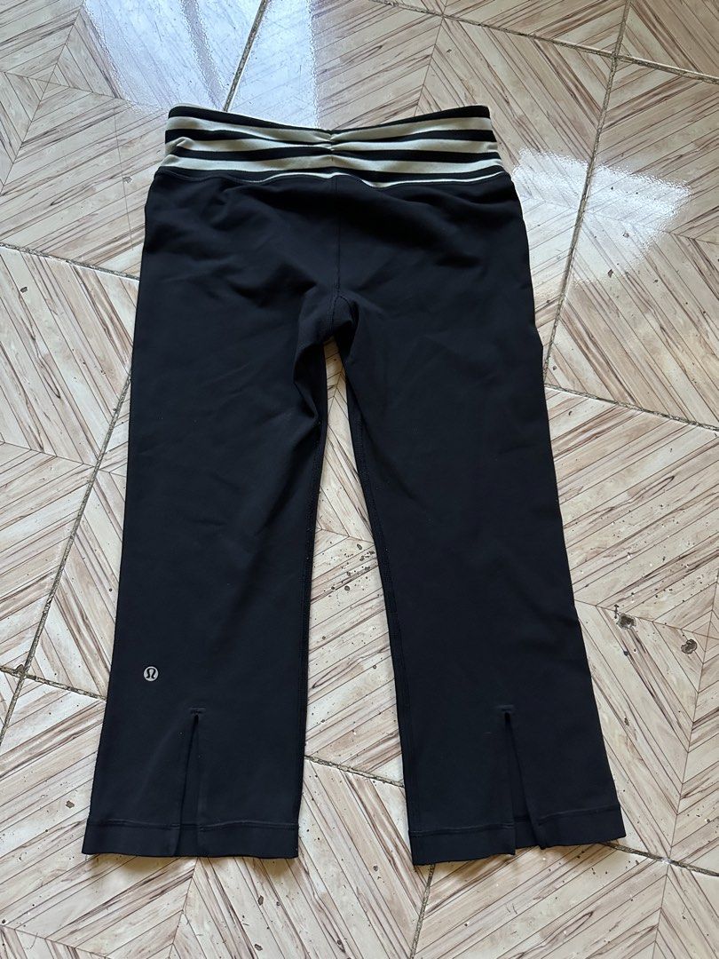 Lululemon Black Crop Leggings Size 8 (Category: Activewear) located in Angeles City. Submitted by alejeong27 (Listing ID 1468335840, Image 2). Description: - Brand: Lululemon - Color: Black - Size: 8 (tag inside waistband) - Features: Foldover waistband with black/white stripes, small slit at back cuffs, and reflective logo near hem - Condition: Pre-loved with a small hole on the right leg (kindly check the photos closely before buying).