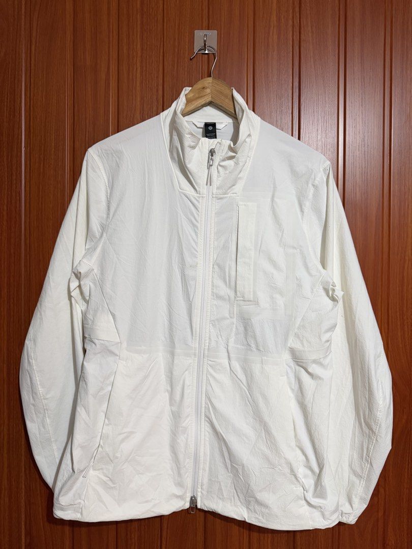 Lululemon White Lightweight Full Zip Jacket Size S (Category: Coats, Jackets and Outerwear) located in Manila. Submitted by tlfph (Listing ID 1468295050, Image 2). Description: - Brand: Lululemon - Style: Full zip jacket with high neck collar and chest pocket - Color: White - Size: S - Material: Lightweight nylon and elastane blend - Features: Long sleeves with elastic cuffs, iconic Lululemon logo on the back hem - Condition: Clean and ready to w