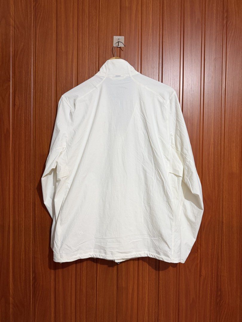Lululemon White Lightweight Full Zip Jacket Size S (Category: Coats, Jackets and Outerwear) located in Manila. Submitted by tlfph (Listing ID 1468295050, Image 3). Description: - Brand: Lululemon - Style: Full zip jacket with high neck collar and chest pocket - Color: White - Size: S - Material: Lightweight nylon and elastane blend - Features: Long sleeves with elastic cuffs, iconic Lululemon logo on the back hem - Condition: Clean and ready to w