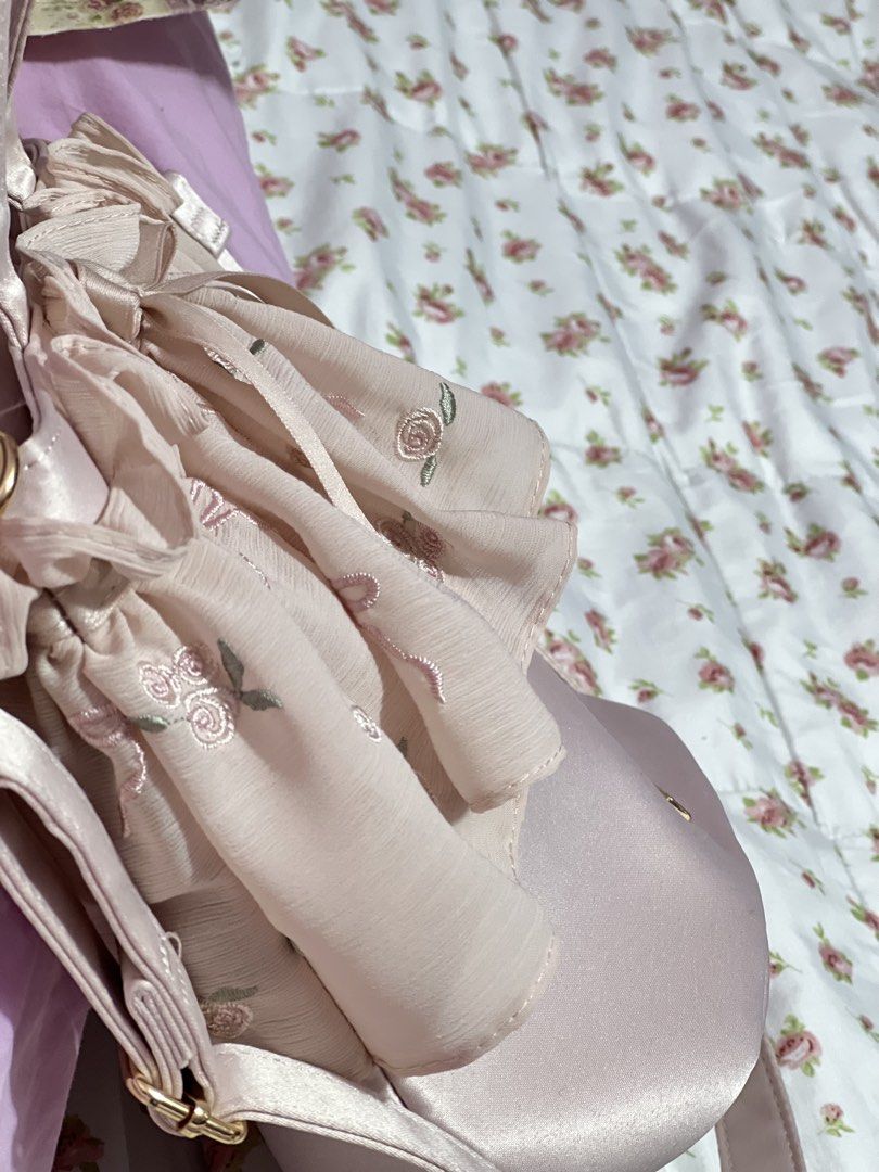 Maison de FLEUR Pink Rose Embroidered Ruffle Bag (Category: Shoulder Bags) located in Pasig City. Submitted by morilove (Listing ID 1468300948, Image 3). Description: Maison de FLEUR pink bag with embroidered roses and bows on the ruffle overlay. Satin fabric finish with gold tone hardware plaque. Dual top handles plus a long shoulder strap. Interior has a pink fabric lining, slip pocket, and a branded tag. Magnetic snap closure at top..