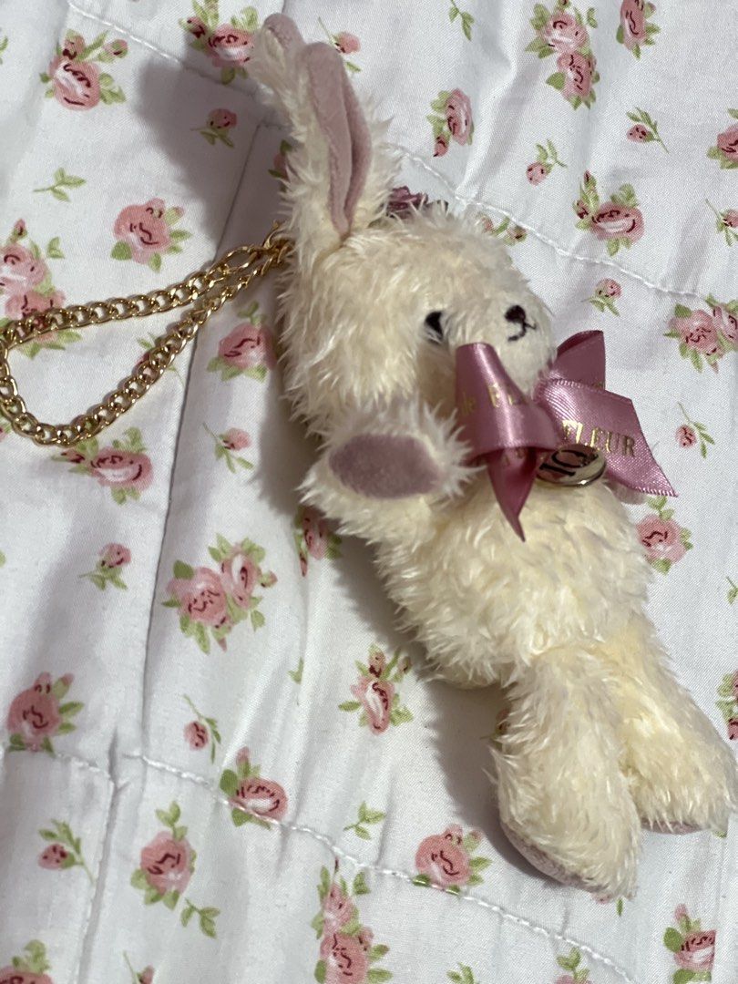 Maison de FLEUR Rabbit Plush Bag Charm (Category: Plushies & Soft Toys) located in Pasig City. Submitted by morilove (Listing ID 1468302544, Image 3). Description: - Brand: Maison de FLEUR - Item: Fluffy white bunny plush charm - Accents: Pink satin branded ribbon, rose detail between ears, and 10th-anniversary round metallic charm - Hardware: Gold-tone chain for bags or keys - Condition: Brand new with tags.