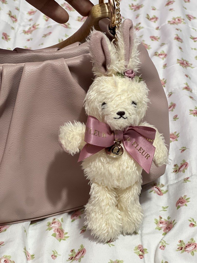Maison de FLEUR Rabbit Plush Bag Charm (Category: Plushies & Soft Toys) located in Pasig City. Submitted by morilove (Listing ID 1468302544, Image 2). Description: - Brand: Maison de FLEUR - Item: Fluffy white bunny plush charm - Accents: Pink satin branded ribbon, rose detail between ears, and 10th-anniversary round metallic charm - Hardware: Gold-tone chain for bags or keys - Condition: Brand new with tags.