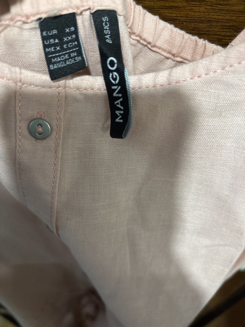 Mango Basics Pink Linen Blend Romper Size XS (Category: Rompers) located in Mandaluyong City. Submitted by clothescarousel (Listing ID 1468440528, Image 3). Description: - Brand: Mango Basics - Size: EU XS / US XXS / MEX ECH - Color: Light pastel pink - Material: Lightweight linen blend - Features: Adjustable spaghetti straps, button-down front, drawstring waist, elasticated back neckline, and cuffed hems - Origin: Made in Bangladesh.