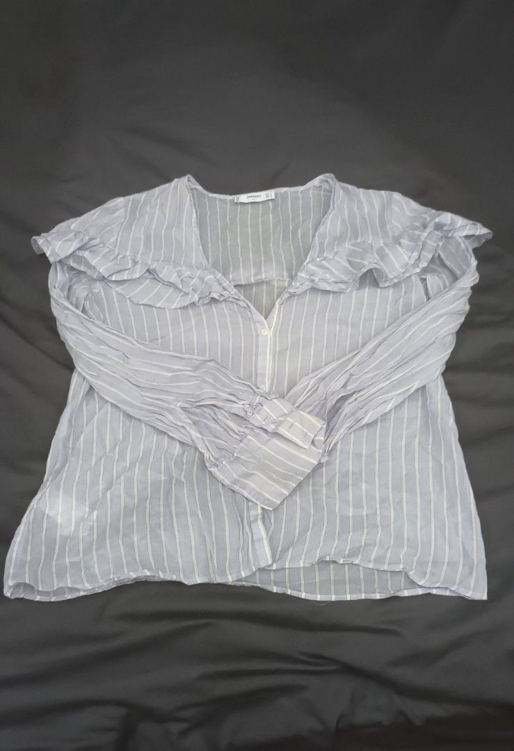 Mango Blue Striped Ruffle Blouse Size M (Category: Blouses) located in Mandaluyong City. Submitted by bestill4610 (Listing ID 1468406175, Image 1). Description: Mango Longsleeves Soft light cotton Ruffle accent V-neckline, botton-down Never used. just needs washing W 21" x L 24".