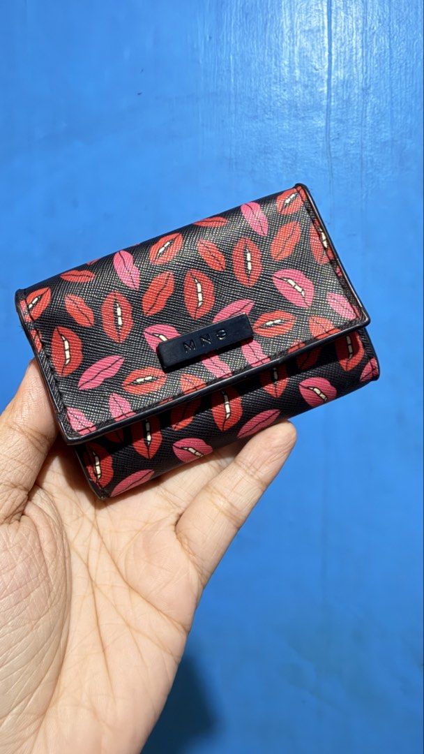 Mango Lips Print Coin Purse (Category: Wallets & Card holders) located in San Pablo. Submitted by dtanne (Listing ID 1468358661, Image 1). Description: - Brand: MNG - Style: Compact coin purse - Design: Black with a vibrant red and pink lips pattern - Details: Small rectangular black engraved brand plate on front flap - Structure: Structured shape, perfect for bags of any size.