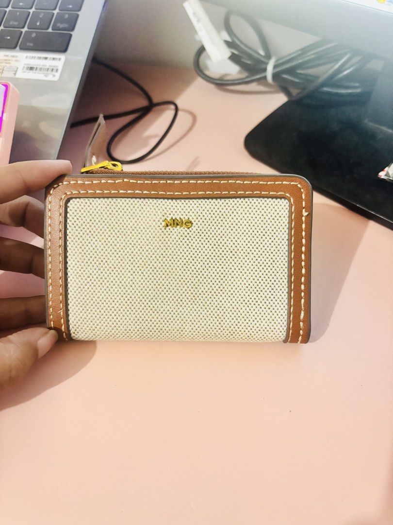 Mango MNG Canvas and Brown Leather Wallet (Category: Wallets & Card holders) located in Cavite. Submitted by gianflores (Listing ID 1468471522, Image 1). Description: - Brand: Mango - Material: Beige canvas with brown faux leather - Hardware: Gold-tone MNG logo - Compartments: Zip-around coin pocket on top + snap button closure with multiple card slots - Size: Compact, perfect for small bags - Condition: Brand new with tag still tucked inside the