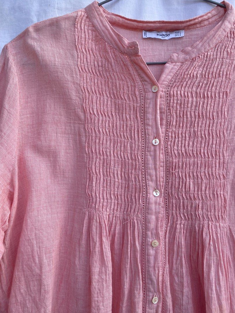 Mango Suit Pink Button-Up Blouse (Category: Blouses) located in Baguio. Submitted by royalriver17 (Listing ID 1468435822, Image 3). Description: - Brand: Mango Suit - Color: Pink - Size: EUR L / USA 8 / MEX G - Design: Button-up with smocked front detailing, mandarin collar, and long sleeves - Material: Textured lightweight fabric - Origin: Made in India - Styling: Versatile piece, easily pairs with denim or trousers.