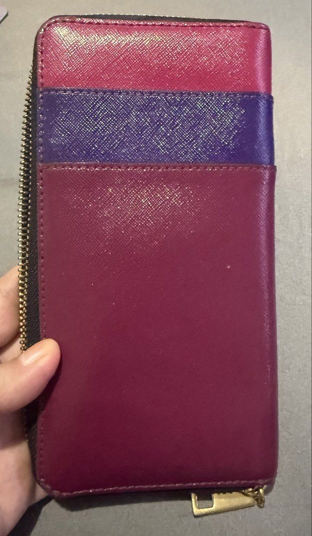 Marc Jacobs Zip Around Wallet Pink Purple (Category: Wallets & Card holders) located in Cainta. Submitted by mykee1 (Listing ID 1468372377, Image 3). Description: - Brand: Marc Jacobs - Style: Long zip-around wallet - Color: Pink and purple block design - Material: Textured Saffiano leather - Hardware: Gold-tone metal with branded zipper pull - Details: Stamped front logo - Interior: Multiple card slots and compartments for daily organization.