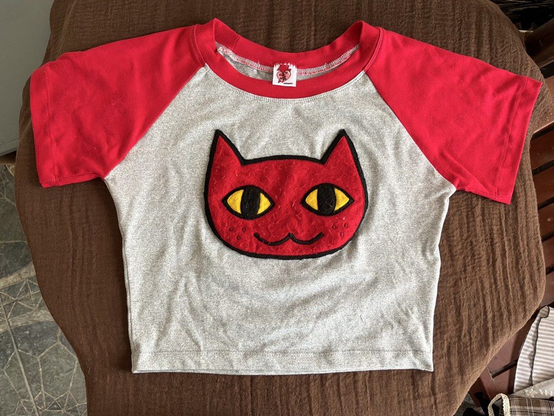 Marceline Adventure Time Red and Grey Cat Face Patch Raglan Crop Top (Category: Shirts) located in Dumaguete. Submitted by _l1lyy_ (Listing ID 1468339189, Image 1). Description: - Fit: S-M - Style: Short sleeve raglan crop top - Colors: Heather grey with vibrant red - Design: Large red cat patch with yellow/black felt eyes - Fit: Cropped length, ideal for high-waisted jeans or skirts - Material: Soft, comfortable cotton blend - Details: Features 