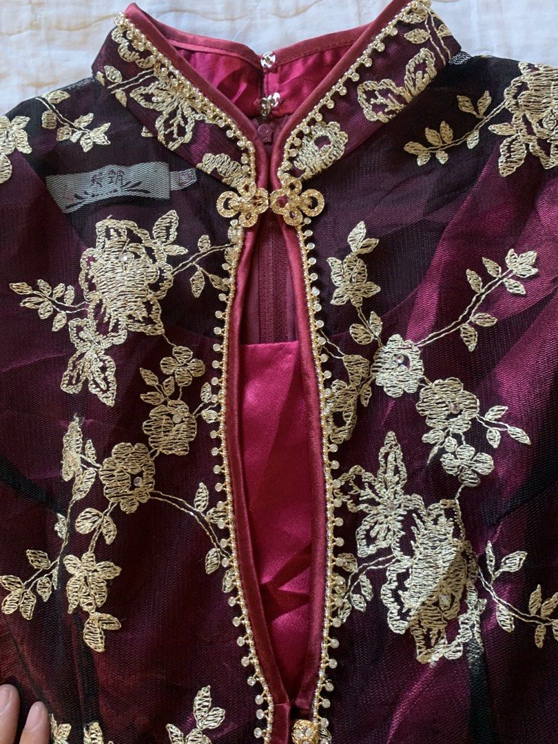 Maroon and Gold Embroidered Mandarin Collar Top (Category: Blouses) located in Sarangani. Submitted by solune_clo (Listing ID 1468404643, Image 2). Description: - Color: Deep maroon with gold floral embroidery - Design: Mandarin collar with beaded trim, front clasp closure, and sheer mesh panels - Fit: Fitted silhouette with a stylish flared lace hem - Sleeves: Short cap sleeves - Closure: Convenient back zip closure - Condition: Excellent pre-lo