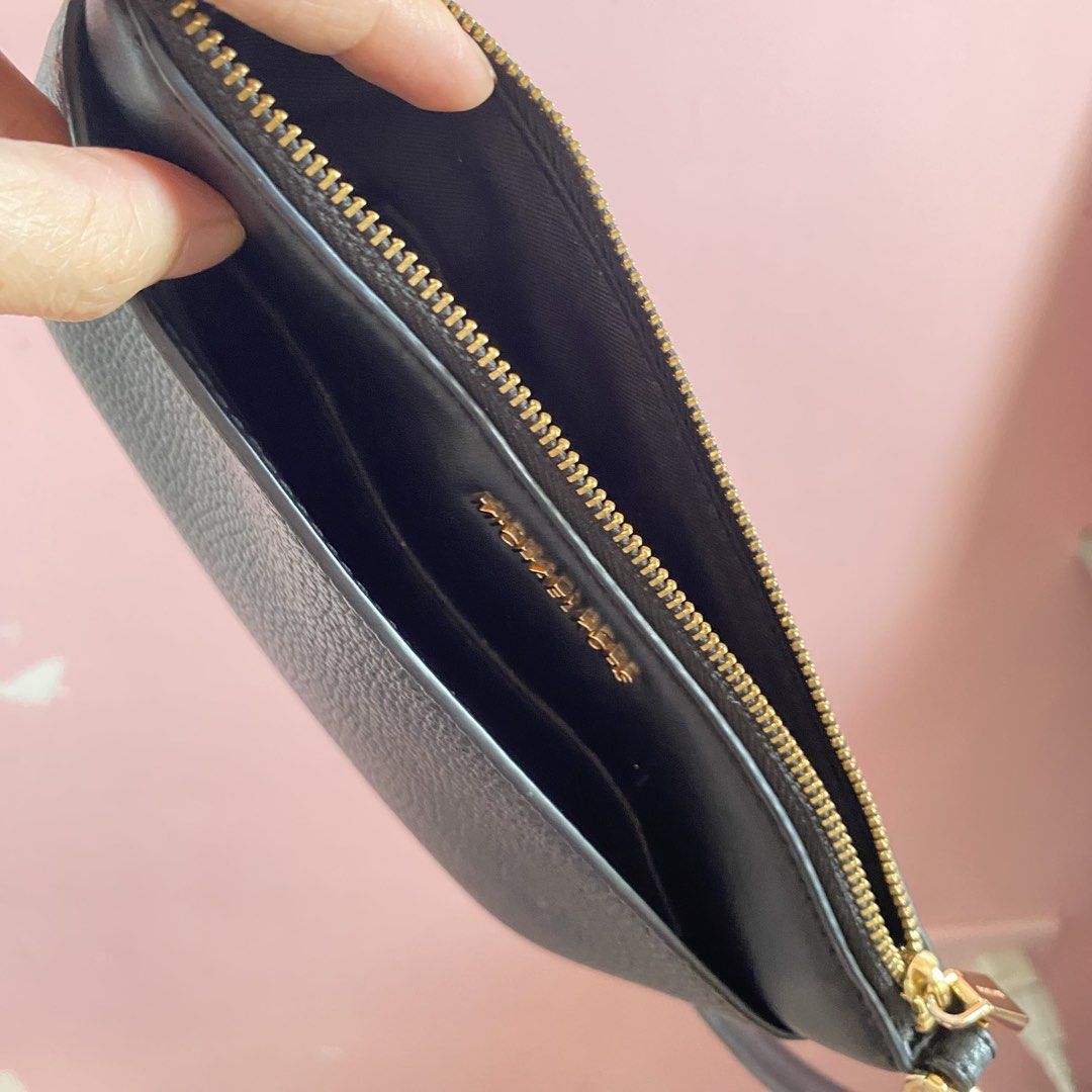 Michael Kors Black Leather Wristlet Pouch (Category: Luxury Bags & Wallets) located in Imus. Submitted by wheagirl (Listing ID 1468284315, Image 3). Description: - Brand: Michael Kors - Material: Black pebbled leather with gold hardware - Closure: Secure top zip closure - Interior: Fabric-lined with built-in card slots and a slip pocket - Convenience: Includes an attached side wrist strap - Condition: Great for quick errands, holds cash and cards