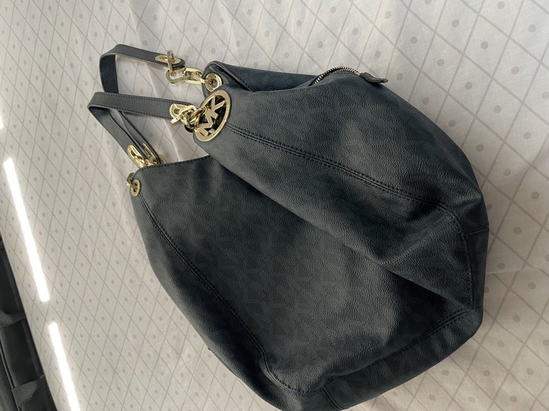 Michael Kors Black Monogram Hobo Shoulder Bag (Category: Luxury Bags & Wallets) located in Quezon City. Submitted by tor_ash (Listing ID 1468322405, Image 2). Description: Michael Kors hobo bag in dark monogram print. Textured finish, gold hardware, and metal MK circle logo rings on the straps. Interior lined in light fabric with a zip pocket and slip pockets. Zip closure across the top. Spacious slouchy shape, comfortable to carry on the shoulde