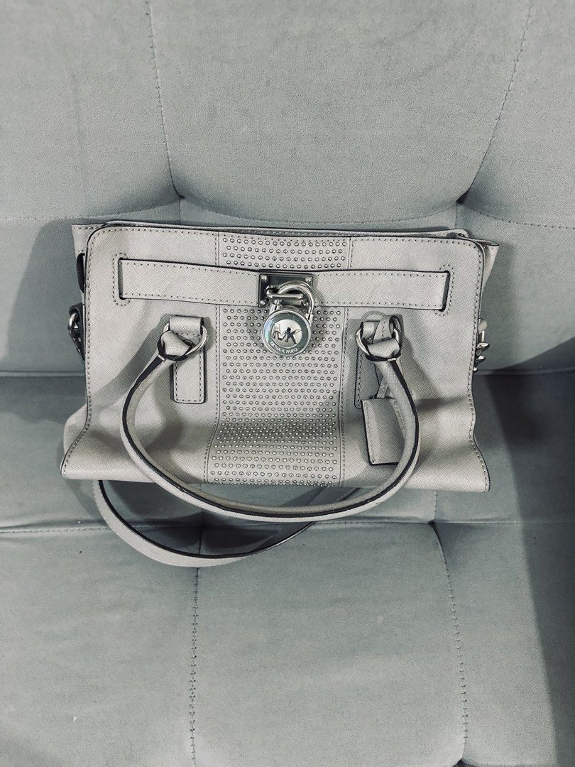 Michael Kors Gray Studded Satchel Handbag (Category: Luxury Bags & Wallets) located in Tarlac. Submitted by via_banana (Listing ID 1468352049, Image 1). Description: - Brand: Michael Kors - Material: Durable gray Saffiano leather - Hardware: Silver-tone with chic padlock accent and side chain links - Compartments: Center zip divider with multiple interior slip and zip pockets - Straps: Double top handles and an adjustable/removable shoulder strap