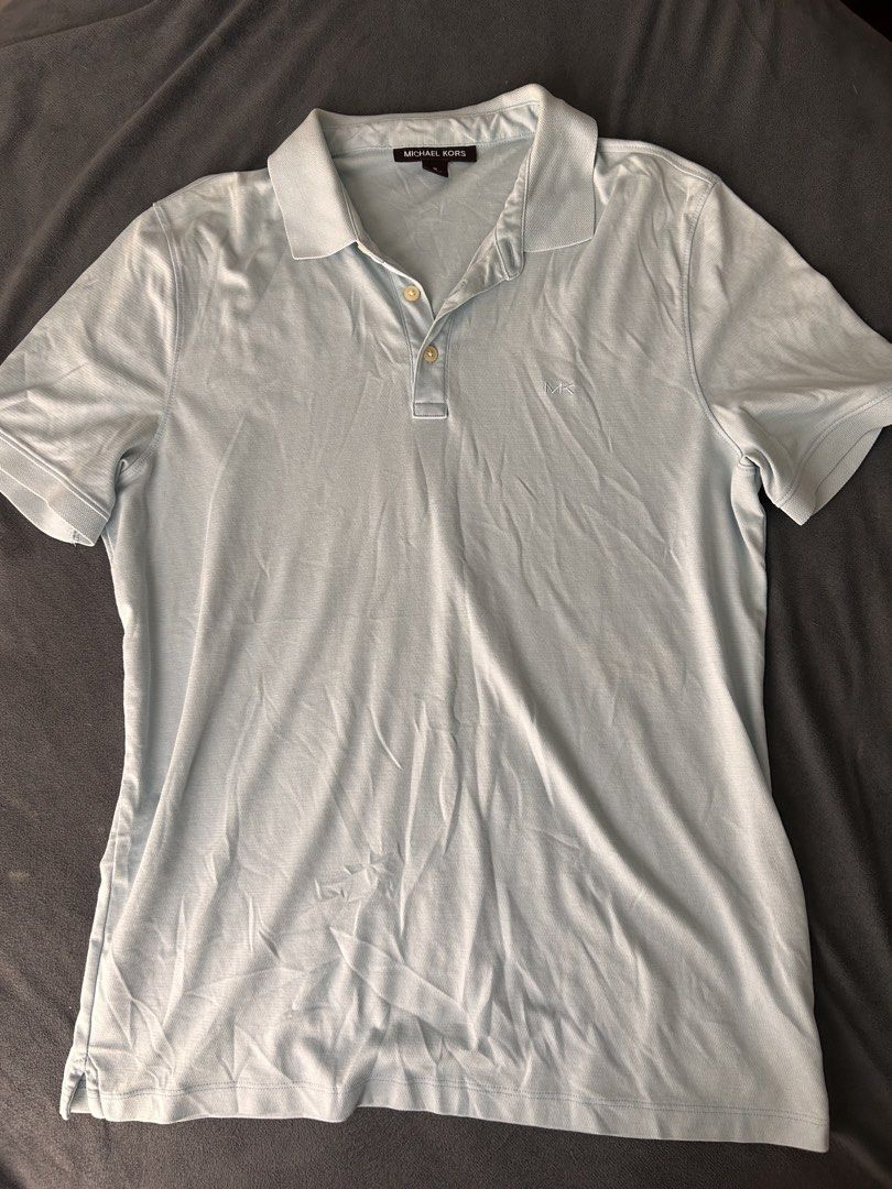 Michael Kors Light Blue Polo Shirt (Category: Tshirts & Polo Shirts ) located in Pasig City. Submitted by cha.declutterz (Listing ID 1468327334, Image 1). Description: - Brand: Michael Kors - Color: Light Blue - Size: Medium - Material: Breathable textured fabric (Made in Peru) - Details: Classic collar, two-button placket, embroidered MK logo on chest - Condition: Excellent casual everyday piece.