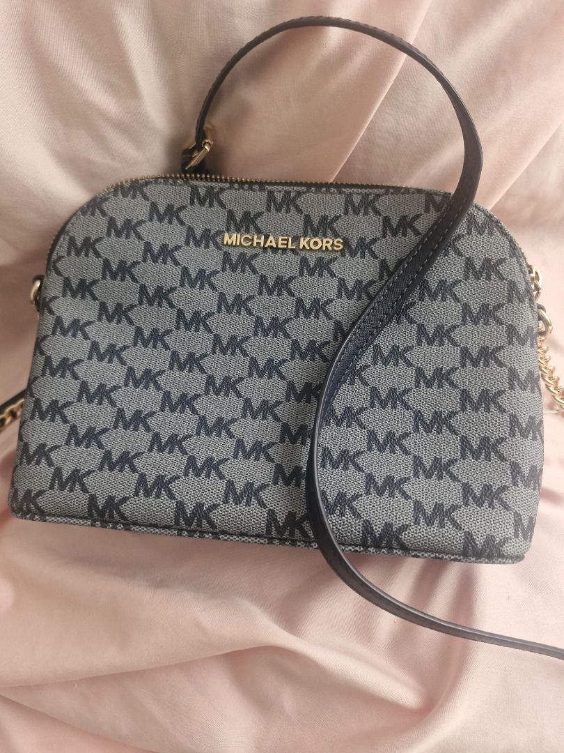 Michael Kors MK Monogram Dome Crossbody Bag (Category: Cross-body Bags) located in Angeles City. Submitted by mycloset525clotheshoppe (Listing ID 1468292393, Image 1). Description: - Authentic Michael Kors dome crossbody bag - Classic grey and black MK monogram print - Elegant gold hardware accents with centered logo lettering - Secure top zipper closure - Includes short handle strap and long adjustable shoulder strap with chain detail - Compact 