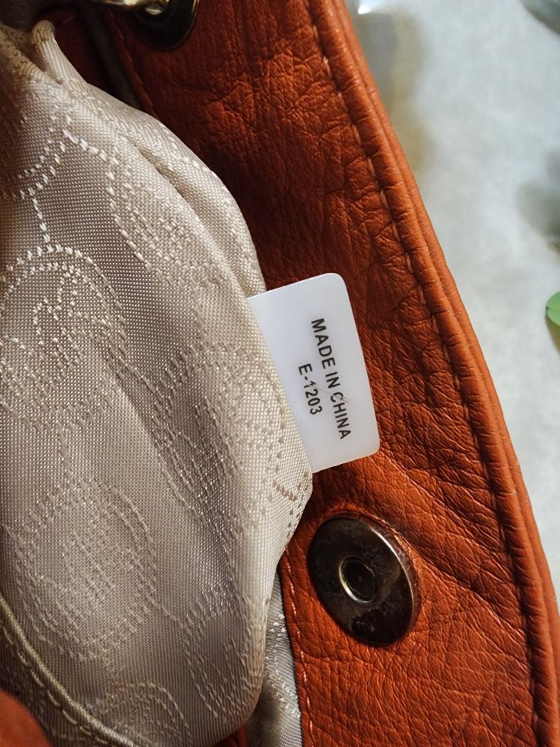 Michael Kors Orange Leather Shoulder Bag with Chain Strap (Category: Luxury Bags & Wallets) located in Caloocan City. Submitted by keenmoon.752ef0 (Listing ID 1466938475, Image 2). Description: - Brand/Model: Authentic Michael Kors leather handbag - Color: Bright orange with shiny gold-tone hardware - Material: Soft and durable pebble leather - Features: Signature MK logo charm and chain straps - Strap: Extra long strap rolled up and attached in 