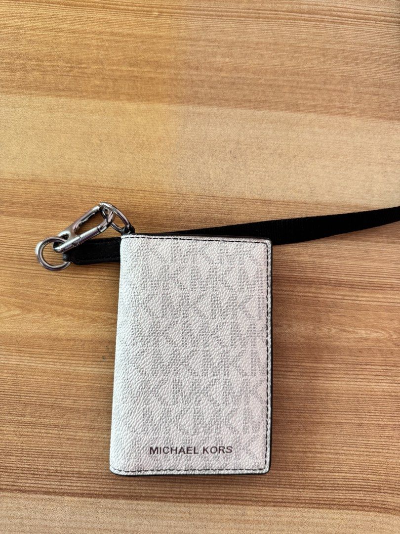 Michael Kors white monogram lanyard card holder (Category: Luxury Bags & Wallets) located in Valenzuela. Submitted by declutterlangpo (Listing ID 1468295839, Image 1). Description: - Brand: Michael Kors - Design: White with signature monogram print and black trim - Features: Clear ID window slot on the back and compact foldover design - Inclusion: Detachable black fabric neck strap with silver-tone metal clasp - Perfect for: Office passes, ID car