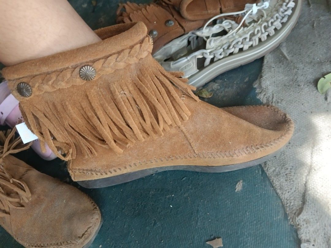 Minnetonka Fringe Suede Boots Brown (Category: Boots) located in Valenzuela. Submitted by relchris22 (Listing ID 1468360613, Image 3). Description: - Brand: Minnetonka - Material: Soft brown suede upper with durable rubber sole - Design: Moccasin-style toe stitching, ankle fringe, braided trim, and metal concho studs - Closure: Convenient side zipper for easy slip-on - Comfort: Perfect and cozy for everyday wear.