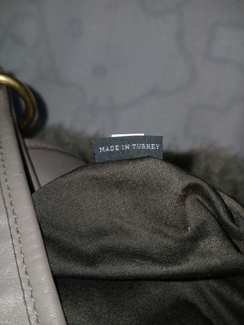 Miu Miu Grey Leather Handbag (Category: Luxury Bags & Wallets) located in Manila. Submitted by chifind_s (Listing ID 1468326099, Image 3). Description: - Color: Sophisticated grey leather - Design: Stylish ruched detailing on the front body with a comfortable braided leather shoulder strap - Hardware: Premium gold-tone accents and secure push-lock closure straps - Interior: Clean brown fabric lining with 'Made in Turkey' tag and ID number tag '19