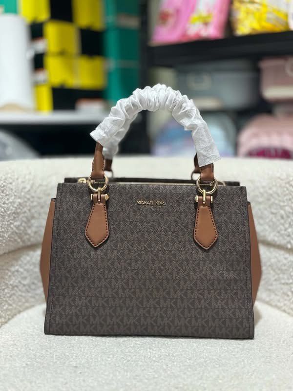 MK Medium Marilyn Satchel (Category: Luxury Bags & Wallets) located in Batangas. Submitted by theprelovedfinds (Listing ID 1468355774, Image 1). Description: - Authentic Michael Kors brown monogram tote bag - Elegant brown leather trim and shiny gold hardware - Secure top zip closure for the main compartment - Spacious interior featuring signature logo lining and a convenient zip pocket - Includes matching detachable shoulder strap for versatile 