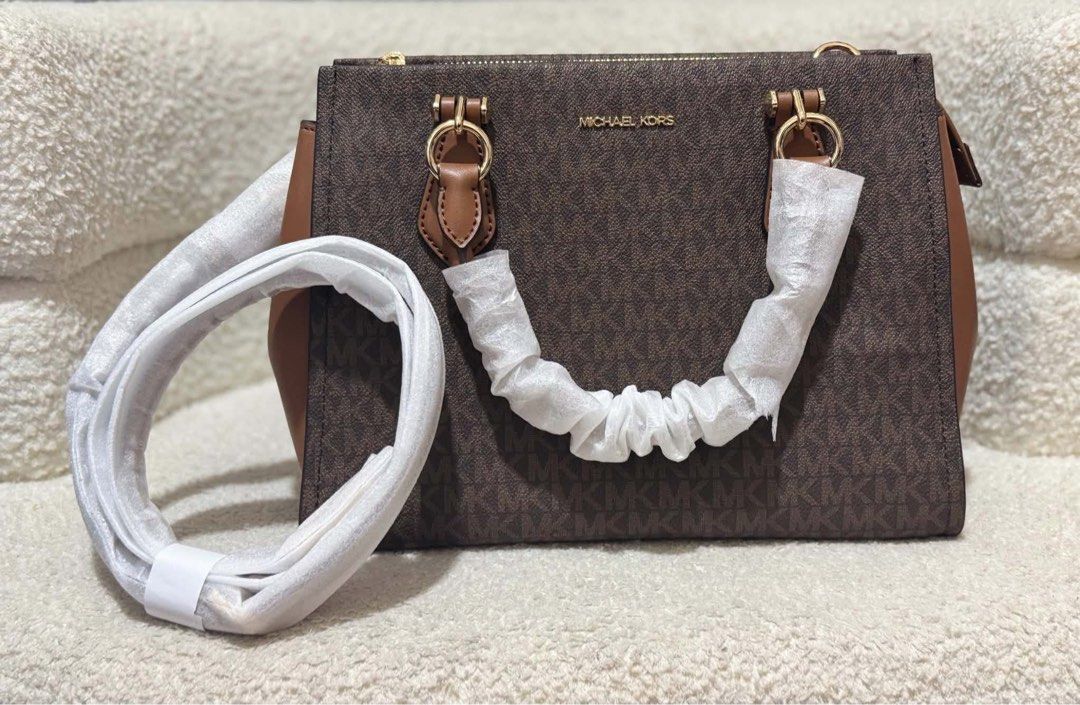 MK Medium Marilyn Satchel (Category: Luxury Bags & Wallets) located in Batangas. Submitted by theprelovedfinds (Listing ID 1468355774, Image 2). Description: - Authentic Michael Kors brown monogram tote bag - Elegant brown leather trim and shiny gold hardware - Secure top zip closure for the main compartment - Spacious interior featuring signature logo lining and a convenient zip pocket - Includes matching detachable shoulder strap for versatile 