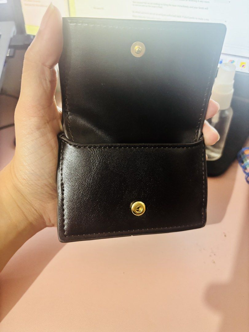 MNG Black Small Wallet Purse (Category: Wallets & Card holders) located in Cavite. Submitted by gianflores (Listing ID 1468471600, Image 2). Description: - Brand: MNG - Color: Classic Black with elegant gold hardware - Closure: Secure snap closure - Compartments: Top zippered pocket with a stylish knotted pull string - Size: Compact, fits easily in small bags and pockets - Condition: Clean interior and exterior, well-maintained.