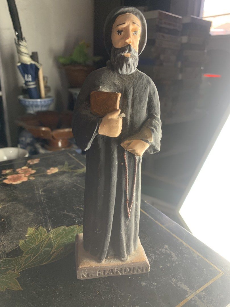 N. Nardini Catholic Saint Monastic Figurine Statue (Category: Religious Items) located in Quezon City. Submitted by sojisup (Listing ID 1468325578, Image 3). Description: - Brand/Maker: N. Nardini - Design: Hand-painted bearded monk/friar in a dark hooded robe holding a book and rosary beads - Material: Solid resin or plaster build with inscribed rectangular base - Condition: Good, with minor surface dust and wear from display - Perfect for colle