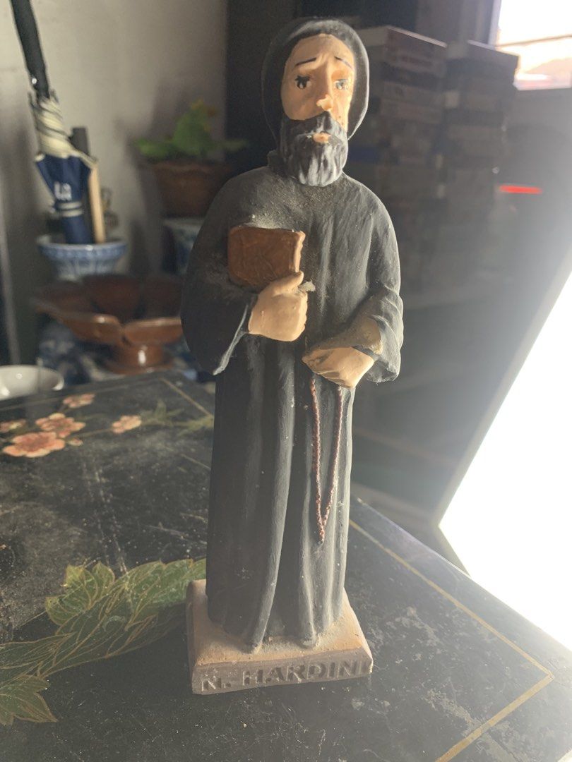 N. Nardini Catholic Saint Monastic Figurine Statue (Category: Religious Items) located in Quezon City. Submitted by sojisup (Listing ID 1468325578, Image 2). Description: - Brand/Maker: N. Nardini - Design: Hand-painted bearded monk/friar in a dark hooded robe holding a book and rosary beads - Material: Solid resin or plaster build with inscribed rectangular base - Condition: Good, with minor surface dust and wear from display - Perfect for colle