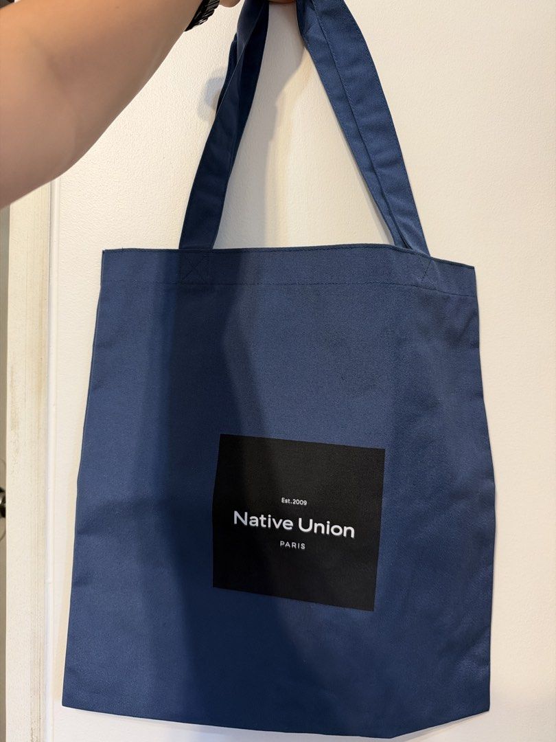 Native Union Paris Canvas Tote Bag Blue (Category: Tote Bags) located in Manila. Submitted by garagesale.fire (Listing ID 1468349717, Image 1). Description: - Brand: Native Union Paris - Color: Navy blue with black front logo patch - Material: Durable cotton canvas - Design: Minimalist everyday carry with secure dual shoulder straps - Versatile use: Great for daily errands, school, or carrying a laptop.