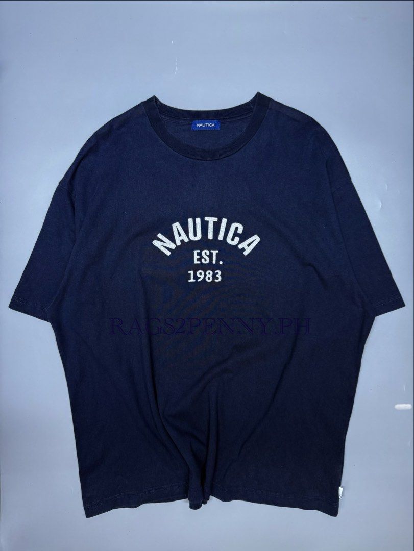 Nautica Arc Logo Navy Blue (Category: Tshirts & Polo Shirts ) located in Kabacan. Submitted by rags2penny.phl (Listing ID 1468337829, Image 1). Description: - Brand: Nautica - Color: Navy blue with white arched logo print (NAUTICA EST. 1983) - Size: XL - Material: 100% cotton for comfort - Details: Ribbed crew neckline, branded tags on lower hem and inner collar - Condition: Clean, solid everyday tee Measurements : 26 x 29.5.