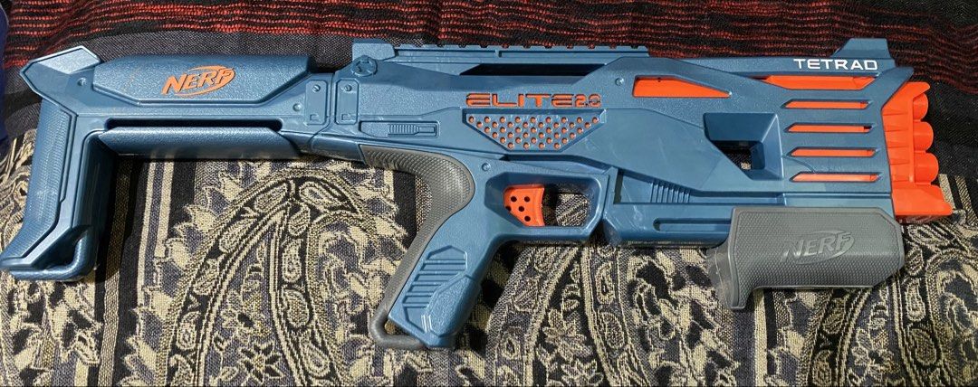 Nerf Elite 2.0 Tetrad Blaster (Category: Action & Battle Toys) located in Baguio. Submitted by thrift_bonita (Listing ID 1468385999, Image 2). Description: - Model: Nerf Elite 2.0 Tetrad toy blaster (Blue and orange) - Firepower: 4 vertical barrels up front for quick successive shots - Action: Pump-action handle and manual trigger, fully functional - Design: Fixed stock at the back with official branding - Condition: Clean plastic body with minor