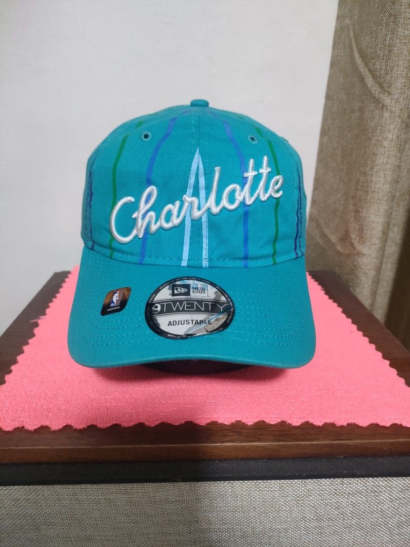 New Era Charlotte Hornets 9TWENTY Adjustable Cap (Category: Caps & Hats) located in Santa Rosa. Submitted by abj_104 (Listing ID 1468304860, Image 1). Description: - Authentic New Era 9TWENTY Cap in Teal - Features embroidered Charlotte script on the front - Unique striped vertical pattern on the crown - Rare NBA 75th anniversary tag on the side - Adjustable strapback closure with a silver metal buckle - with original visor sticker still attached