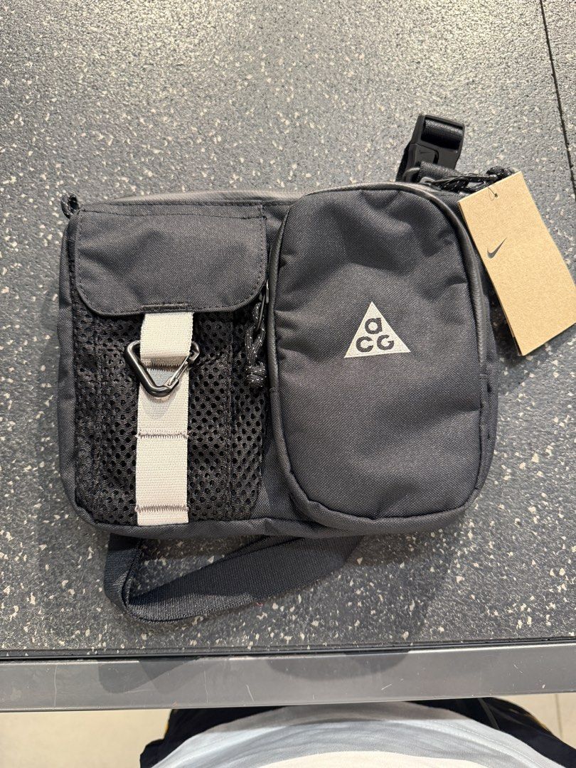 Nike ACG “Daymax” Crossbody bag (Category: Sling Bags) located in Bocaue. Submitted by asys06 (Listing ID 1468337267, Image 2). Description: - Brand: Nike ACG - Color: Black - Condition: Brand new with original tag attached - Material: Durable canvas - Storage: Multiple front zip and mesh pockets - Features: Grey webbing strap, black carabiner clip, and adjustable shoulder strap - Best for: Daily essentials or outdoor adventures.