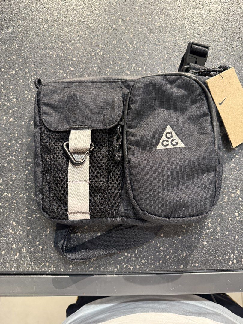 Nike ACG “Daymax” Crossbody bag (Category: Sling Bags) located in Bocaue. Submitted by asys06 (Listing ID 1468337267, Image 1). Description: - Brand: Nike ACG - Color: Black - Condition: Brand new with original tag attached - Material: Durable canvas - Storage: Multiple front zip and mesh pockets - Features: Grey webbing strap, black carabiner clip, and adjustable shoulder strap - Best for: Daily essentials or outdoor adventures.