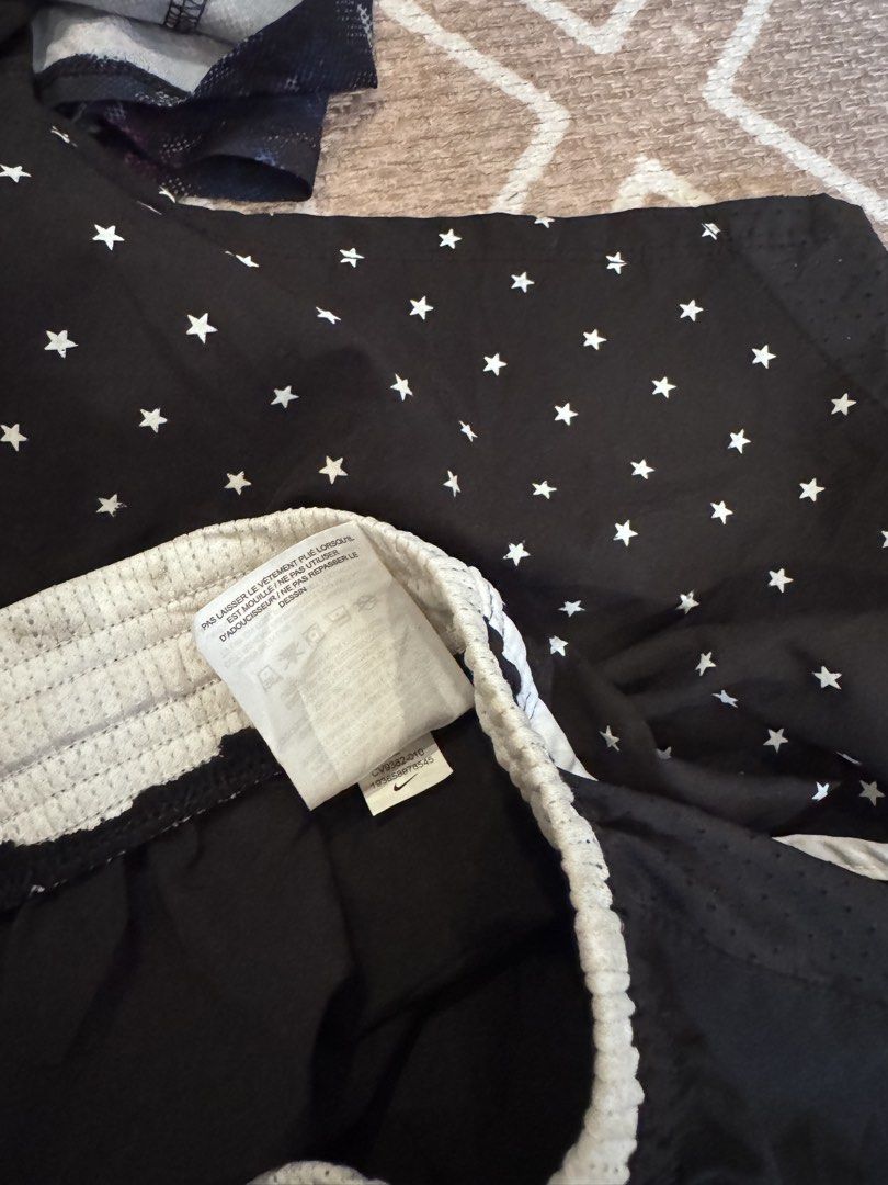 Nike and Avia athletic shorts bundle size L (Category: Shorts) located in Bulacan. Submitted by zyannechlo86360 (Listing ID 1468413421, Image 2). Description: Two pairs of athletic shorts. One pair is Nike with a star pattern and white drawstring waist. Second pair is Avia with a dark floral and abstract pattern, inner lining included. Both shorts feature elastic waistbands. Great for workouts, running, or casual gym wear. Size L for kids or yout