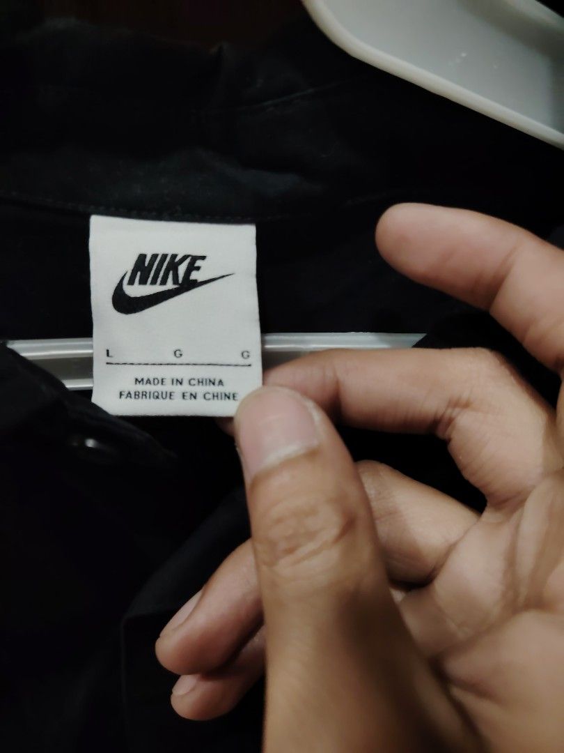 Nike Black Button-Up Shirt with Chest Pocket Size L (Category: Tshirts & Polo Shirts ) located in Calapan. Submitted by thriftopia_12 (Listing ID 1468416607, Image 2). Description: - Brand: Nike - Color: Black - Size: Large - Style: Short-sleeve button-up shirt with classic collar - Details: Single chest pocket with white embroidered Nike logo, front button closure - Hem: Adjustable drawstring hem for a custom fit - Origin: Made in China.