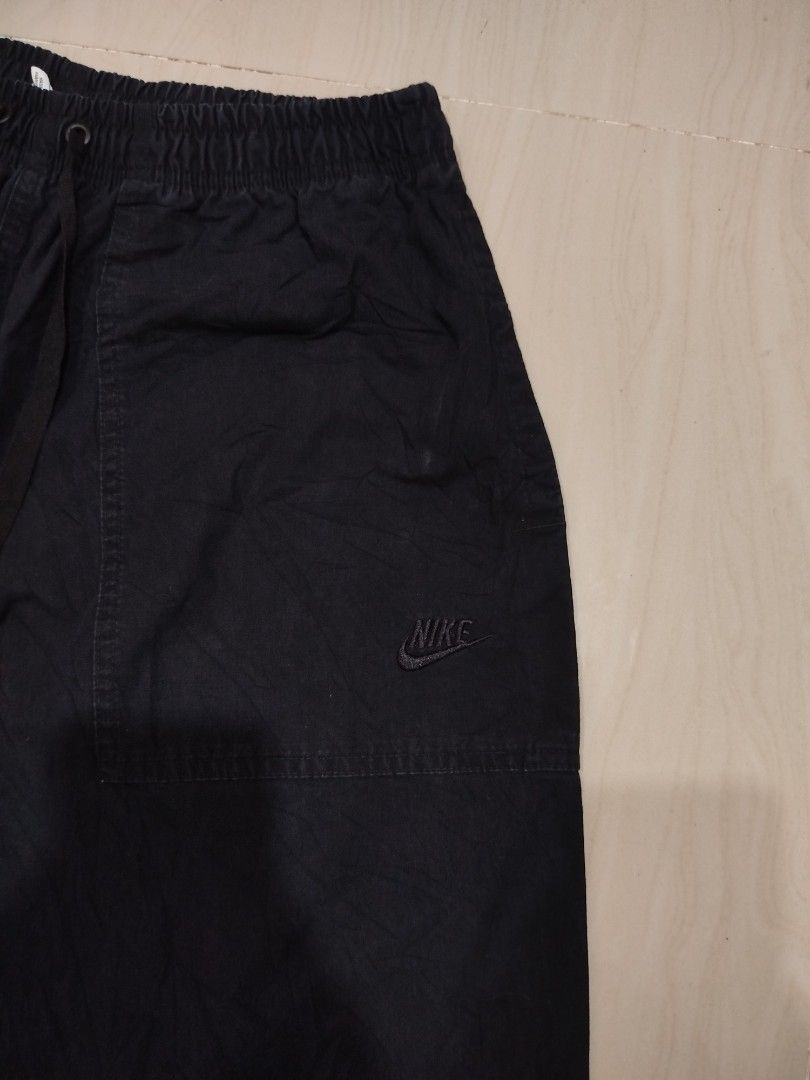 Nike Chino Pants (Category: Joggers) located in Aroroy. Submitted by dr0p-a-dr1p (Listing ID 1468331409, Image 2). Description: Waist: 30-34 Length: 40 10/10 color rate - Brand: Nike - Color: Black - Size: Medium (Tag sewn inside) - Origin: Made in Vietnam - Waistband: Elastic with adjustable drawstrings - Details: Embroidered black Nike logo on upper left pocket - Cuffs: Adjustable drawstring cords for custom cinching - Style: Great for everyday