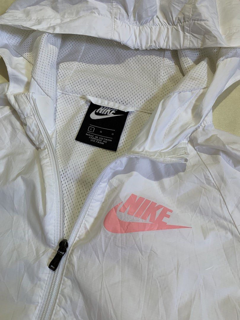 Nike Pink White Windbreaker Jacket BQ6487-101 Size L (Category: Coats, Jackets and Outerwear) located in Davao. Submitted by cheineebau09680 (Listing ID 1468313721, Image 2). Description: - Brand: Nike - Style: Pink and white colorblock windbreaker jacket (Style Code: BQ6487-101) - Size: Large (tag inside) - Material & Origin: Lightweight fabric with breathable mesh lining, made in Vietnam - Features: Full zip closure and attached hood - Conditio