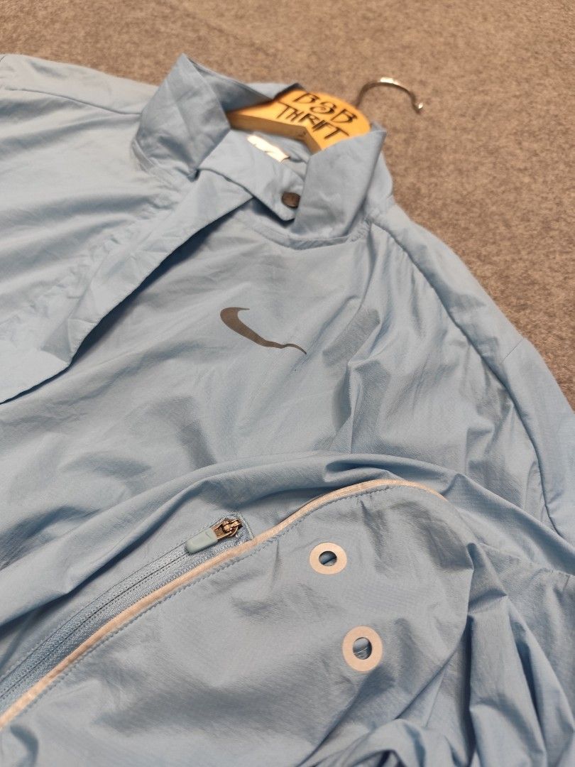 Nike Running Division Packable Windbreaker Jacket (Category: Coats, Jackets and Outerwear) located in Cordova. Submitted by bsb.streetluxvintage.clothing (Listing ID 1468423666, Image 3). Description: - Brand: Nike - Color: Light Blue - Size: Small - Full front zip closure with snap button collar - Elasticated hem and cuffs for a secure fit - Reflective piping details along the arms for visibility - Large zippered pocket on the back - Zipped slee