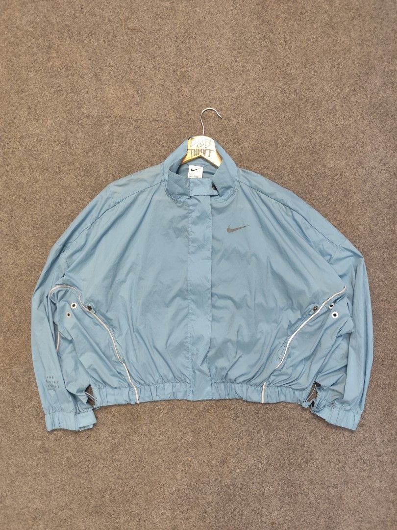 Nike Running Division Packable Windbreaker Jacket (Category: Coats, Jackets and Outerwear) located in Cordova. Submitted by bsb.streetluxvintage.clothing (Listing ID 1468423666, Image 1). Description: - Brand: Nike - Color: Light Blue - Size: Small - Full front zip closure with snap button collar - Elasticated hem and cuffs for a secure fit - Reflective piping details along the arms for visibility - Large zippered pocket on the back - Zipped slee
