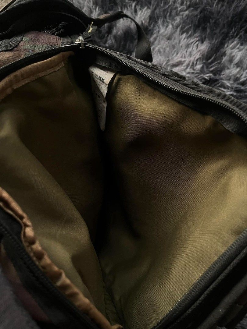 Nike SB Camo Backpack (Category: Backpacks) located in Manila. Submitted by thrift_ni_pambiii (Listing ID 1468344467, Image 3). Description: - Brand: Nike SB - Pattern: Camo with olive green interior lining - Features: Multiple secure zip compartments, heavy-duty front straps, and a front chest buckle strap - Condition: Noticeable tears and fabric damage near the lower back panel area - Best for: Skateboarding, daily commutes, or casual use.