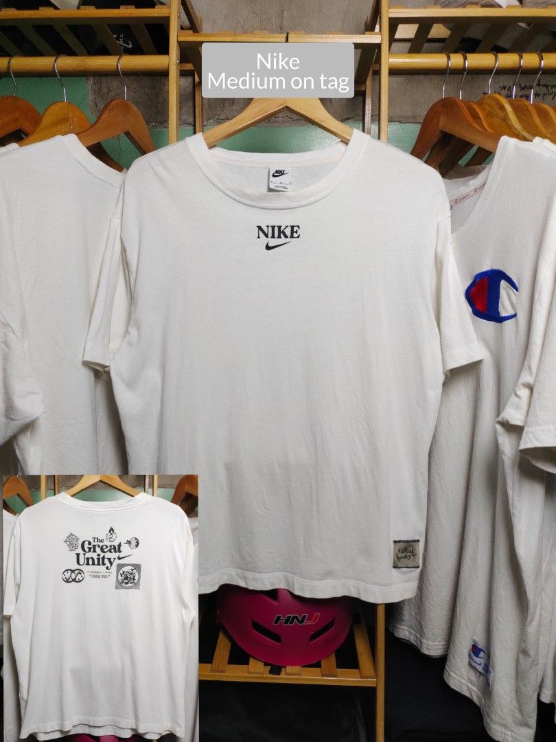Nike The Great Unity White T-Shirt Medium (Category: Tshirts & Polo Shirts ) located in Tayabas. Submitted by lorrena (Listing ID 1468436842, Image 1). Description: - Brand: Nike - Color: White - Size: Medium - Design: Centered chest branding with small woven label near the hem - Back Print: 'The Great Unity' graphic with symbols and small swoosh logo - Condition: Clean fabric, neutral, and easy to match with daily outfits.