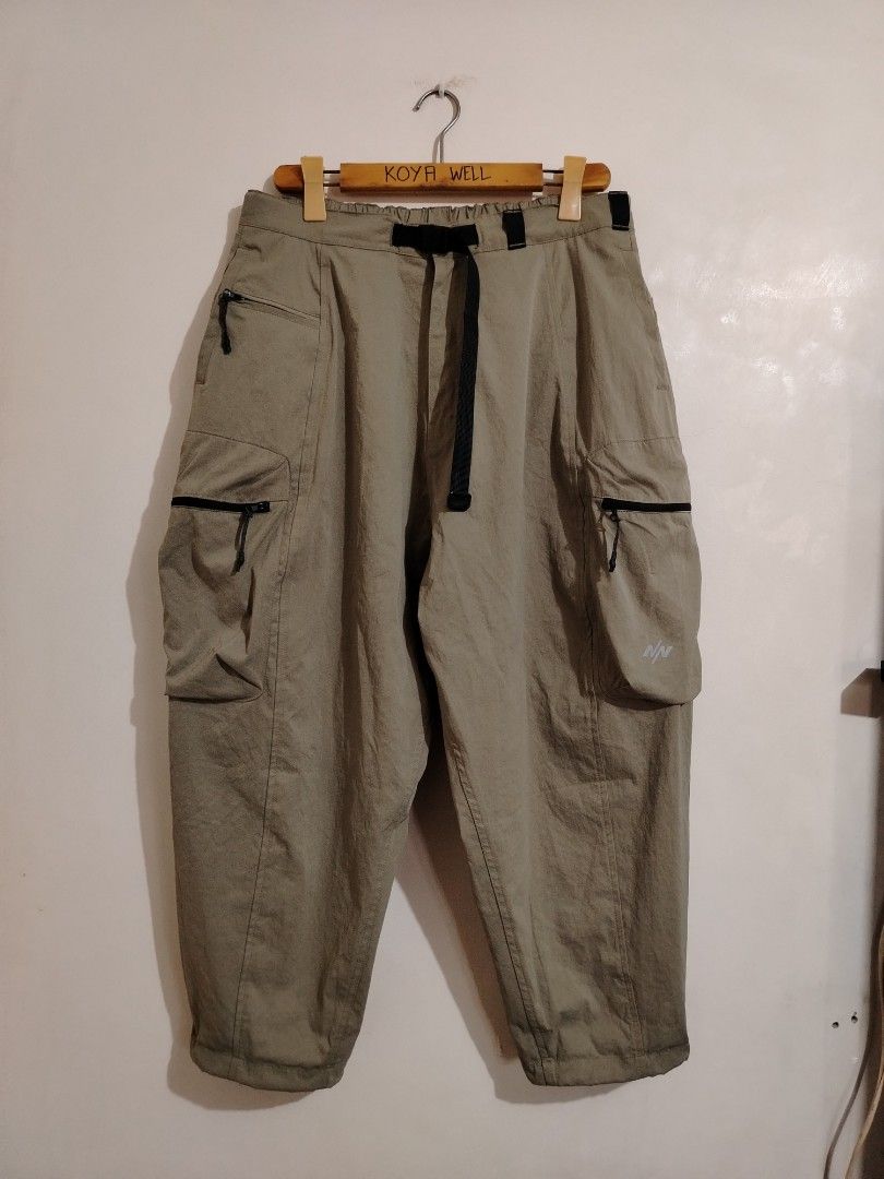Nine. Nine Cargo Pants Olive Green Size M (Category: Trousers) located in Cavite. Submitted by koyawell.ph (Listing ID 1468348632, Image 1). Description: - Brand: N9 - Color: Olive green - Size: Medium - Material: 100% polyester (machine wash cold, hang to dry) - Waist: Elastic waistband with integrated strap and buckle - Pockets: Multiple functional zippered cargo pockets on both legs - Details: White N9 logo printed near the lower left pocket.