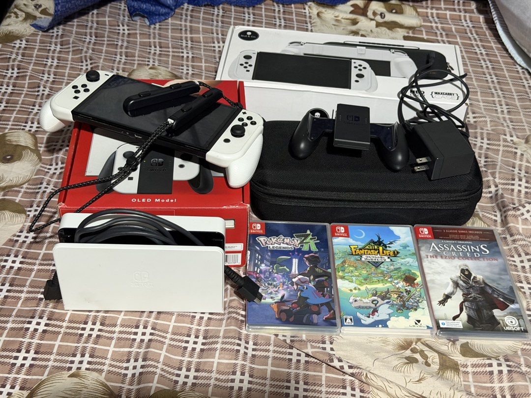 Nintendo Switch OLED Model White with Games and Accessories (Category: Nintendo) located in Manila. Submitted by randomthingsbyjuls (Listing ID 1468445747, Image 3). Description: - Nintendo Switch OLED Model (White) - Original box, white charging dock, AC adapter, and Joy-Con grip included - Skull & Co. MaxCarry case and grip box set included - 3 physical games: Pokemon Legends Z-A, Fantasy Life, and Assassin's Creed The Ezio Collection - Everyth