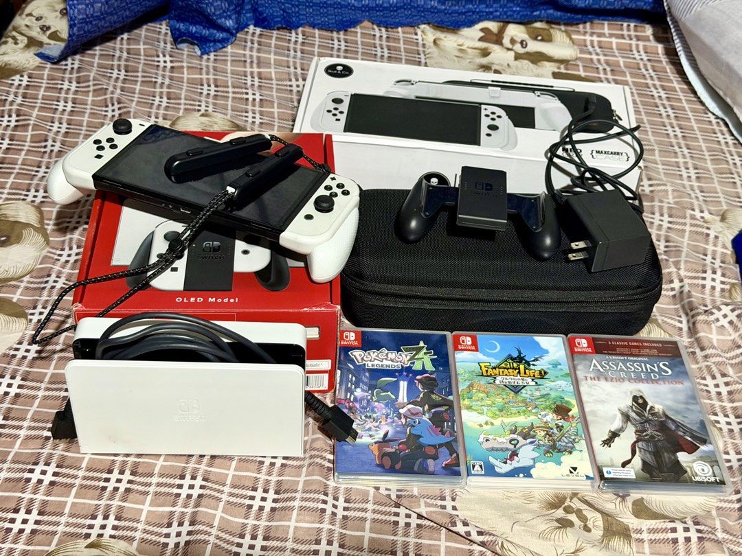 Nintendo Switch OLED Model White with Games and Accessories (Category: Nintendo) located in Manila. Submitted by randomthingsbyjuls (Listing ID 1468445747, Image 2). Description: - Nintendo Switch OLED Model (White) - Original box, white charging dock, AC adapter, and Joy-Con grip included - Skull & Co. MaxCarry case and grip box set included - 3 physical games: Pokemon Legends Z-A, Fantasy Life, and Assassin's Creed The Ezio Collection - Everyth