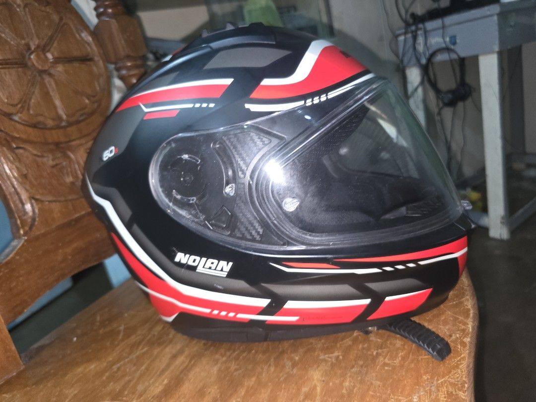 Nolan N60-6 lancer black (Category: Bicycles) located in Cavite. Submitted by s_o.l (Listing ID 1468295635, Image 3). Description: - Model: Nolan N60-6 Full Face Helmet - Colorway: Black, red, and white with graphic design - Size: L (60 cm fit) - Origin: Made in Italy - Features: Built-in sun visor and multiple ventilation ports - Closure: Secure ratchet strap - Authenticity: QR code sticker attached at the back - Condition: Clean interior paddin